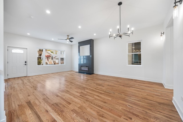 unfurnished living room with light hardwood / wood-style floors and ceiling fan with notable chandelier