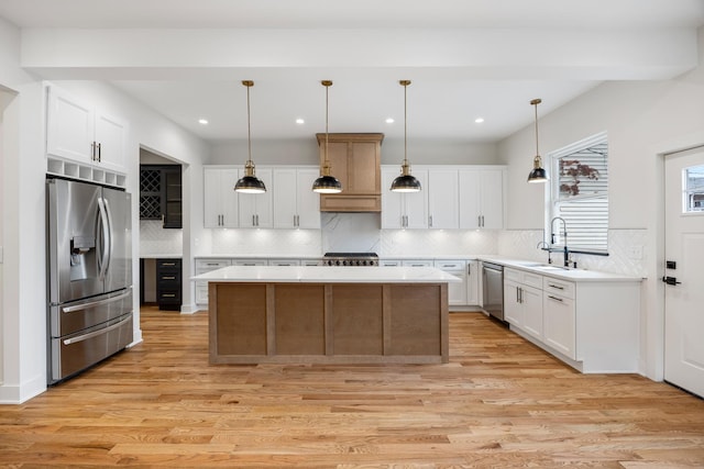 kitchen with pendant lighting, white cabinetry, and appliances with stainless steel finishes