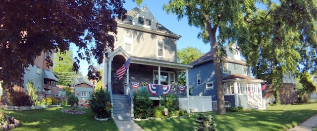 victorian house with a front lawn and covered porch