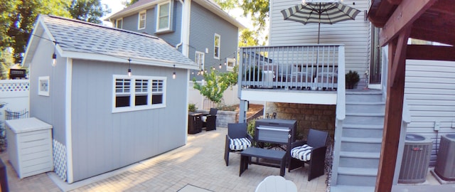 view of patio / terrace featuring cooling unit and a shed