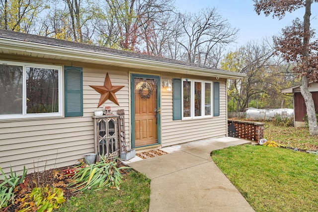 entrance to property with a lawn