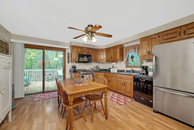 kitchen with decorative backsplash, light wood-type flooring, ceiling fan, sink, and black appliances