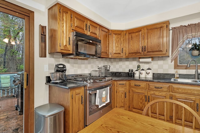 kitchen with decorative backsplash, sink, a healthy amount of sunlight, and stainless steel range with gas stovetop