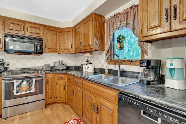 kitchen with appliances with stainless steel finishes, backsplash, light hardwood / wood-style flooring, and sink