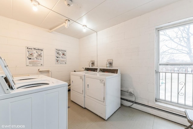 clothes washing area with washer and clothes dryer and a baseboard radiator