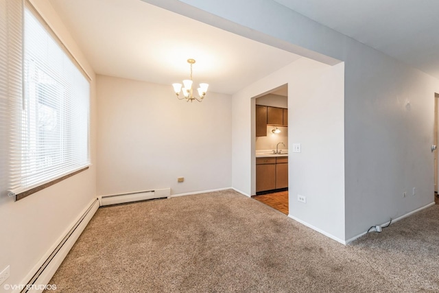 carpeted empty room featuring sink, a baseboard heating unit, and a notable chandelier