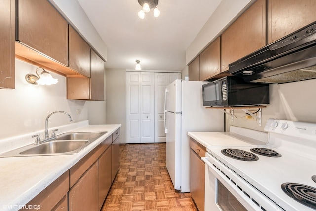 kitchen featuring sink, light parquet floors, extractor fan, and white appliances