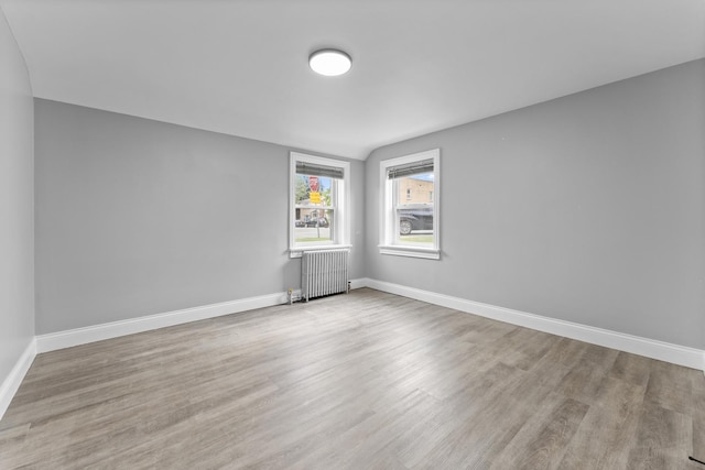 spare room with light wood-type flooring and radiator heating unit