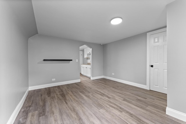 unfurnished living room featuring light wood-type flooring and lofted ceiling