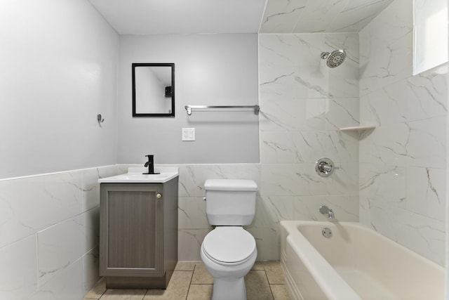 full bathroom with tile patterned floors, vanity, tile walls, toilet, and tiled shower / bath