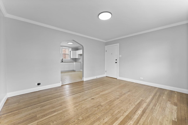 empty room with light hardwood / wood-style floors and ornamental molding