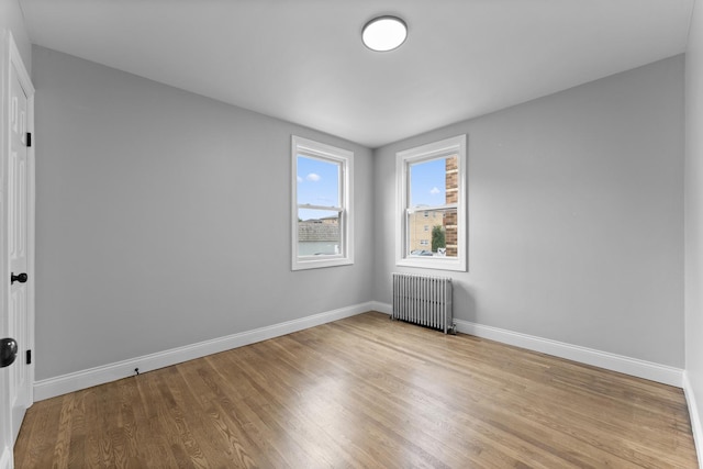 spare room featuring light hardwood / wood-style floors and radiator