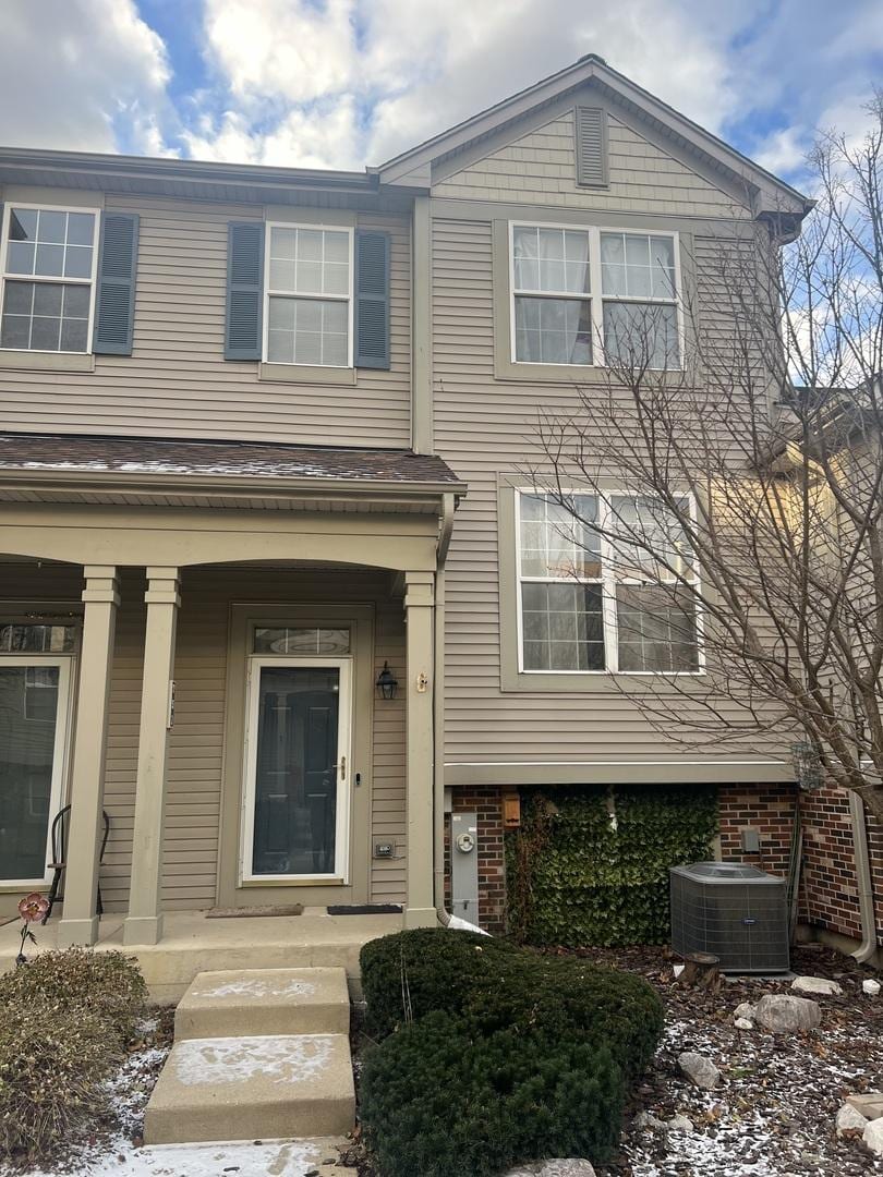 view of front of home with a porch and central AC unit