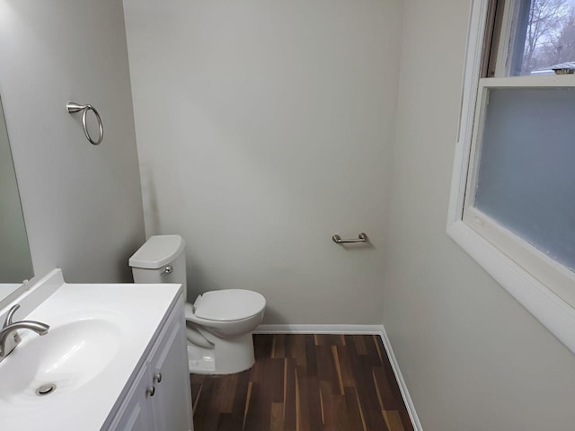 bathroom with toilet, vanity, and hardwood / wood-style flooring