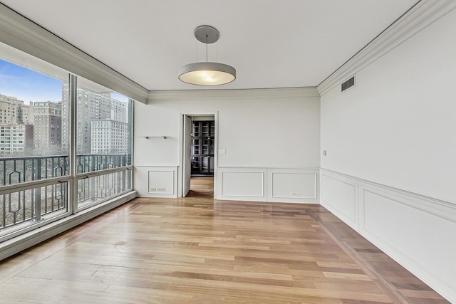 unfurnished dining area featuring light hardwood / wood-style flooring and crown molding