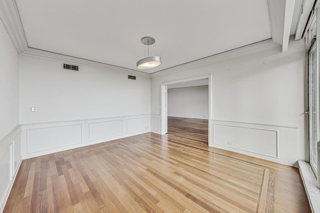 spare room with hardwood / wood-style floors and crown molding