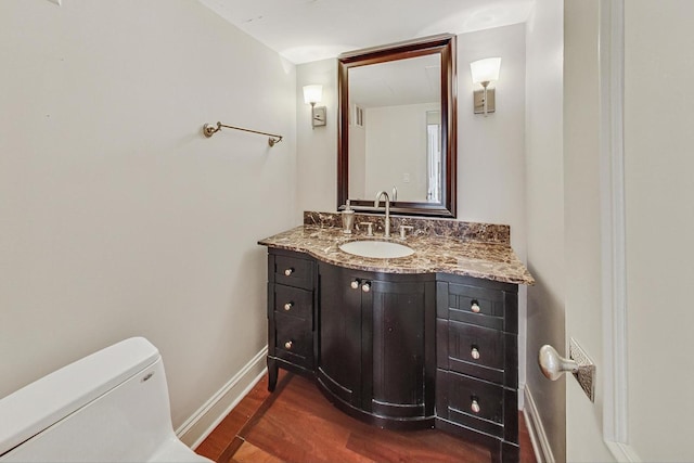 bathroom featuring hardwood / wood-style flooring, vanity, and toilet