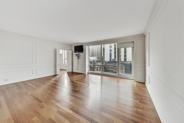 empty room featuring light hardwood / wood-style flooring and ornamental molding