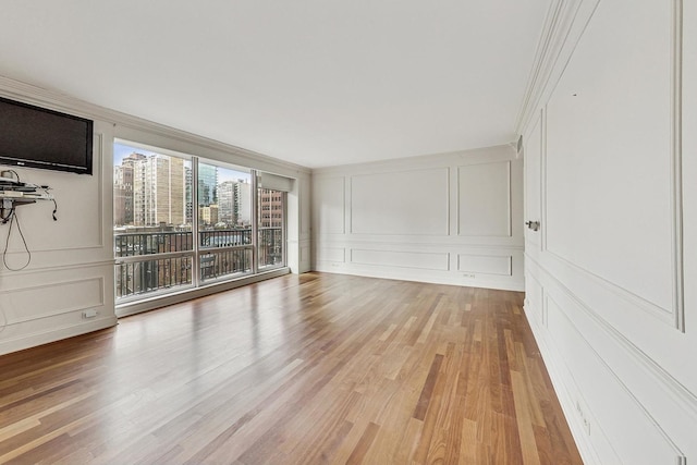 unfurnished living room featuring light hardwood / wood-style floors and crown molding