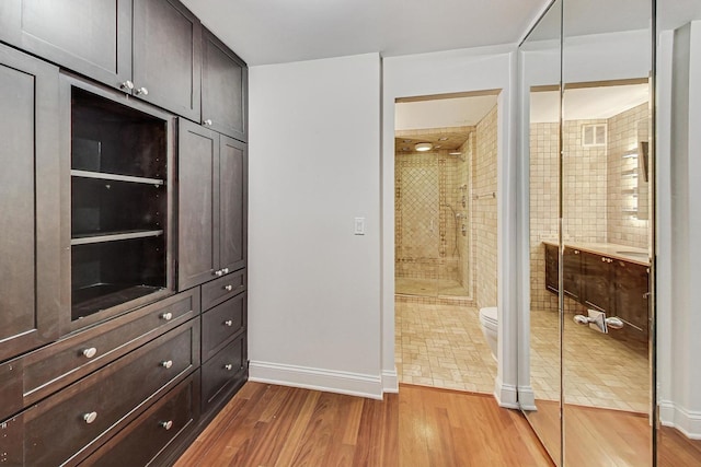 walk in closet with light hardwood / wood-style flooring