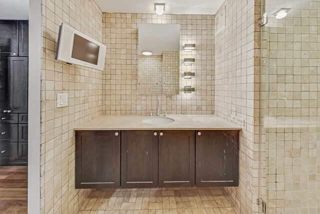 bathroom featuring vanity, tile walls, and walk in shower