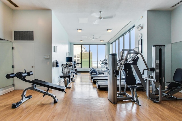 gym with ceiling fan and wood-type flooring