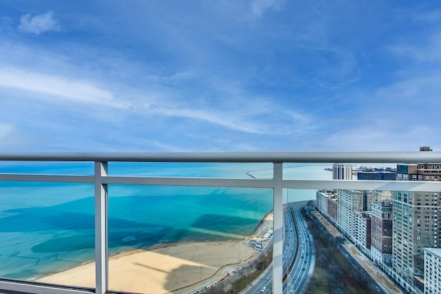 balcony with a water view and a view of the beach