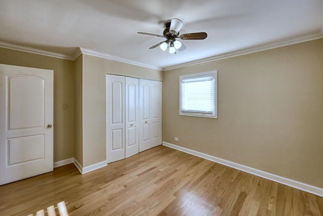 unfurnished bedroom with ceiling fan, a closet, crown molding, and light hardwood / wood-style flooring