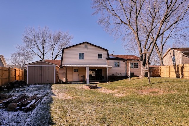 back of property featuring a lawn, a fire pit, and a storage shed