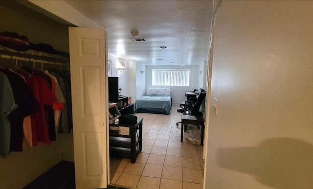 bedroom featuring light tile patterned floors and a closet