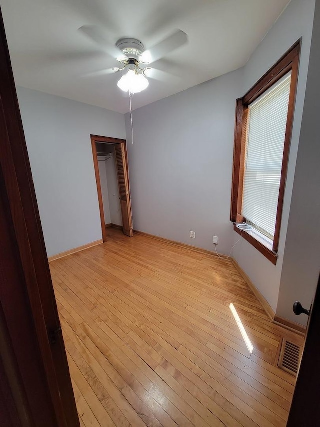 unfurnished bedroom featuring light wood-type flooring, a closet, and ceiling fan