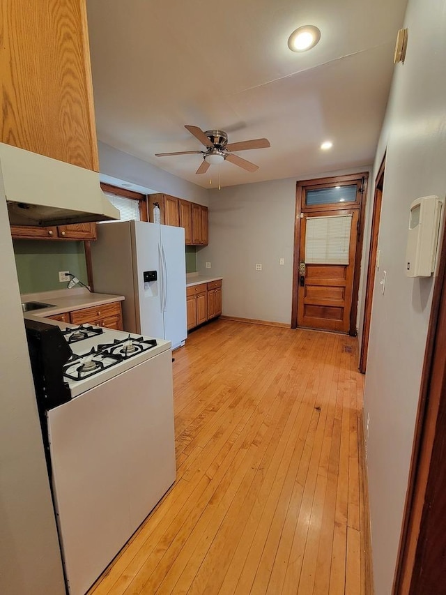 kitchen featuring ceiling fan, white appliances, range hood, and light hardwood / wood-style flooring