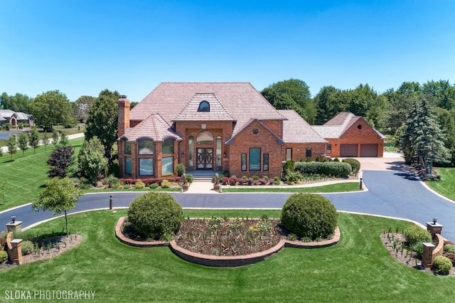 tudor-style house featuring a front yard and french doors