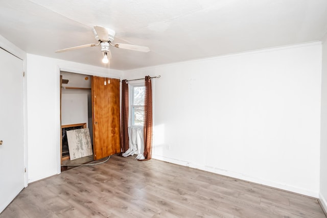 unfurnished bedroom with ceiling fan, a closet, crown molding, and light hardwood / wood-style flooring