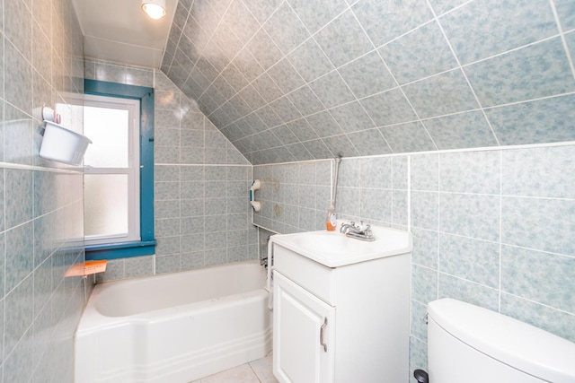 bathroom featuring vanity, vaulted ceiling, tile walls, tile patterned flooring, and toilet