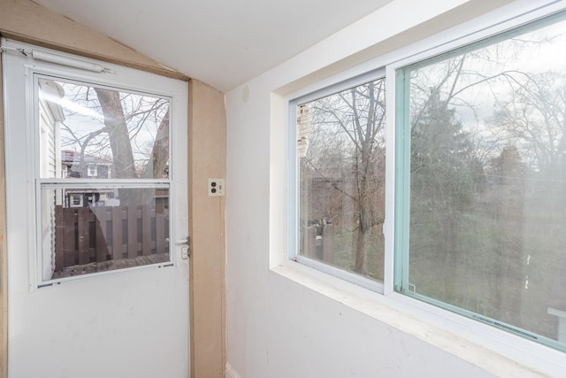 doorway to outside featuring vaulted ceiling