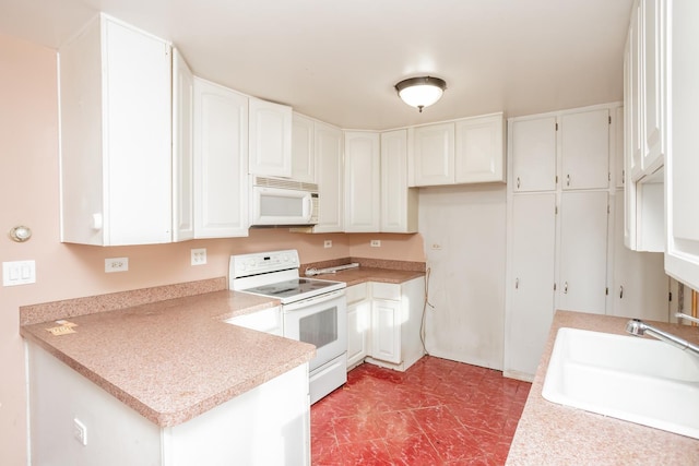 kitchen featuring white appliances, white cabinetry, and sink