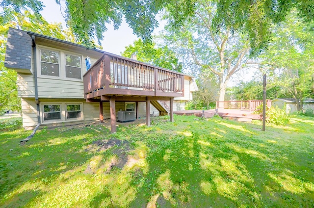 rear view of property with a yard, a deck, and cooling unit