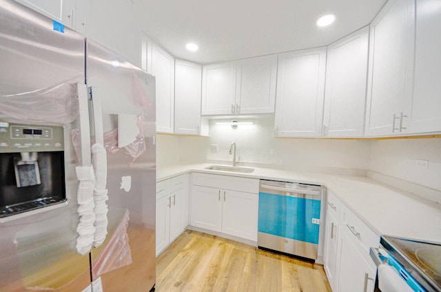 kitchen featuring white cabinets, light wood-type flooring, stainless steel appliances, and sink