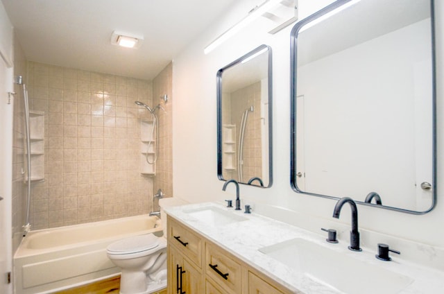 full bathroom featuring vanity, tiled shower / bath combo, and toilet