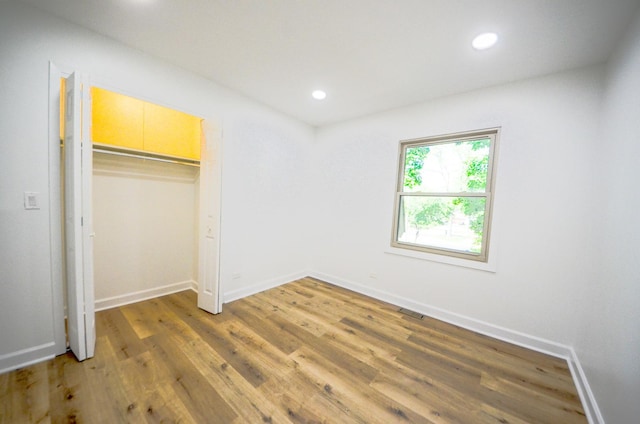 unfurnished bedroom featuring hardwood / wood-style floors and a closet