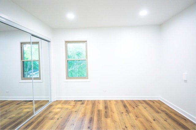 spare room with hardwood / wood-style floors and plenty of natural light