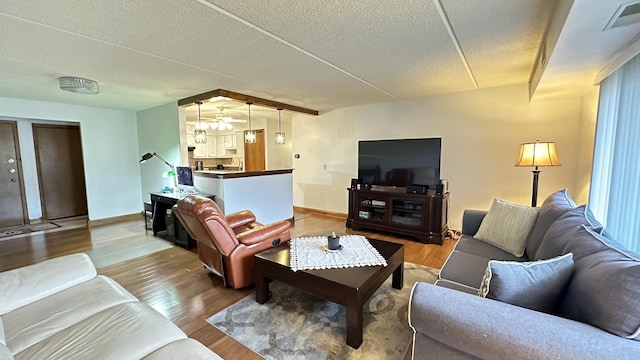 living room with wood-type flooring and a textured ceiling