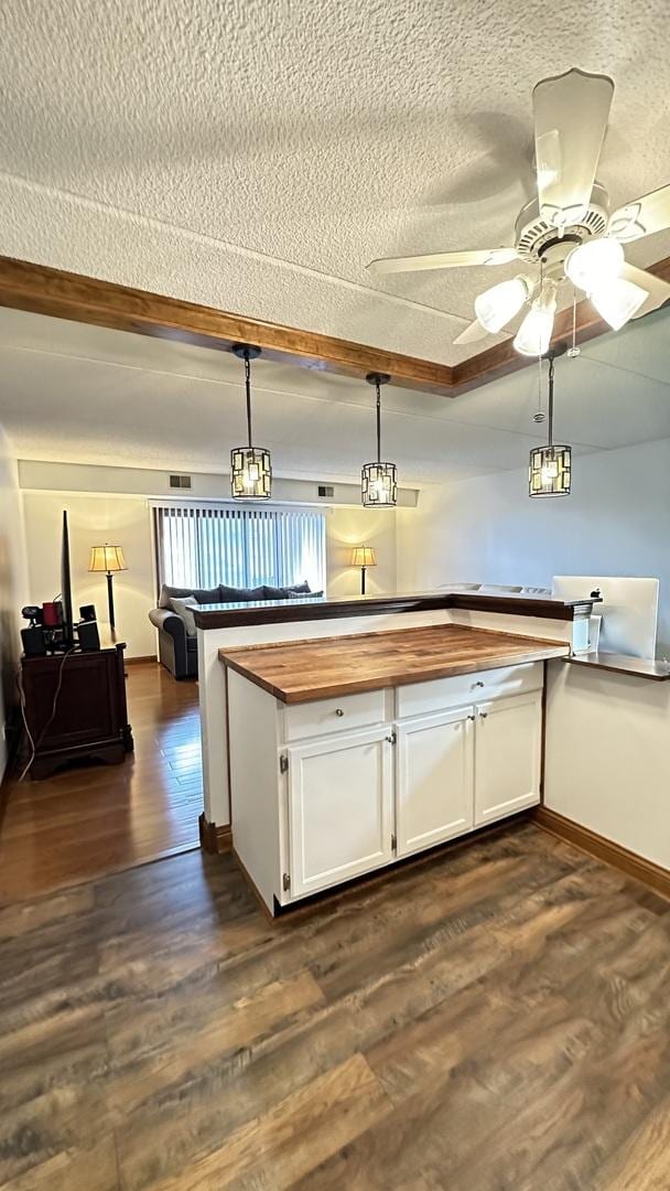 kitchen with dark hardwood / wood-style flooring, white cabinets, pendant lighting, and a textured ceiling