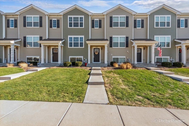 townhome / multi-family property featuring a front lawn