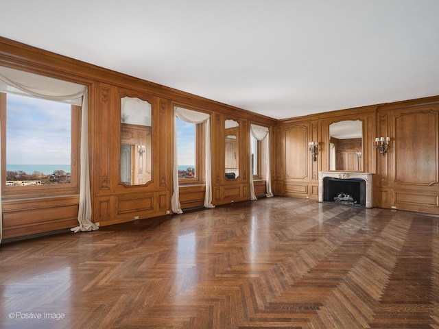 unfurnished living room featuring dark parquet flooring and wooden walls