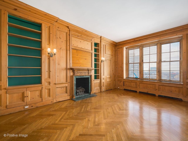 unfurnished living room featuring parquet floors, a fireplace, and wooden walls