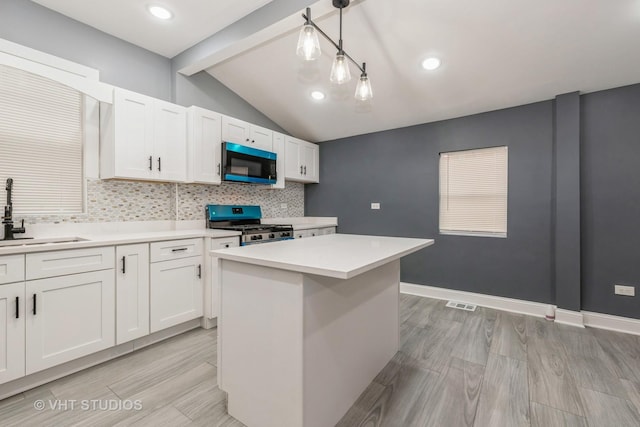 kitchen with pendant lighting, a center island, sink, white cabinetry, and stainless steel appliances