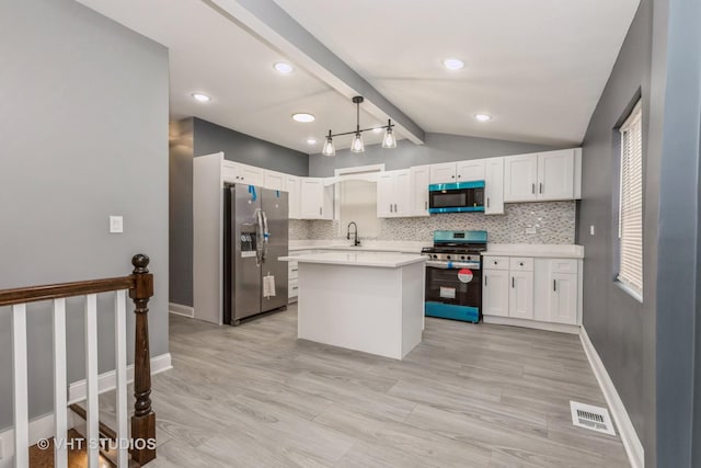 kitchen featuring white cabinets, decorative backsplash, a center island, and appliances with stainless steel finishes