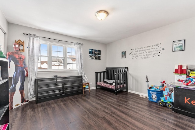 bedroom featuring a crib and dark hardwood / wood-style floors